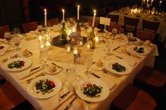 a table set for dinner with candles and plates