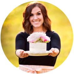 a woman holding a cake with flowers on it