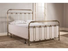 a metal bed frame with white sheets and pillows