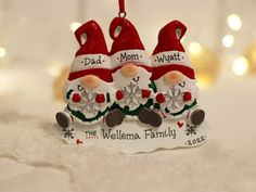 three ceramic christmas ornaments with santa hats and snowflakes on them, sitting on a white surface