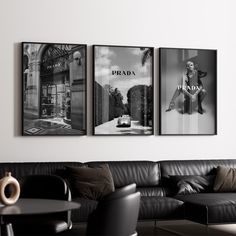 three black and white pictures hang on the wall above a couch in a living room