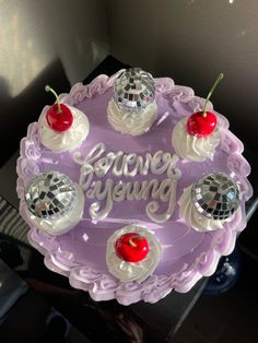 there is a cake that has been decorated with cherries and disco balls on it