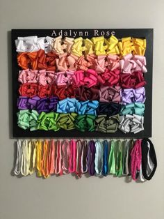 there are many different colors of bows hanging on the wall