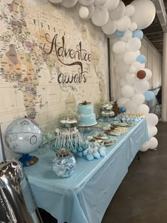 a table topped with lots of blue and white desserts next to a world map