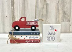 a red truck sitting on top of three books next to a sign that says crackers stars stripes america