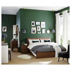 a bedroom with green walls and pictures on the wall