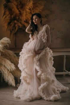 a pregnant woman wearing a dress made out of feathers