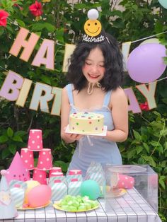 a woman standing in front of a birthday cake