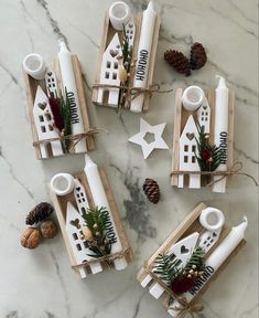 christmas decorations made out of wine bottles on a marble counter top with pine cones and evergreens