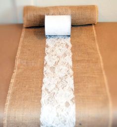 a roll of toilet paper sitting on top of a burlocked table cloth