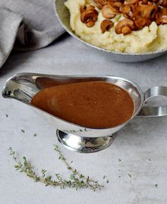 mashed potatoes and gravy in a saucer on a white counter top