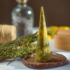 a green cone sitting on top of a piece of wood next to a wooden block