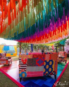 an outdoor area with colorful couches and streamers hanging from it's ceiling