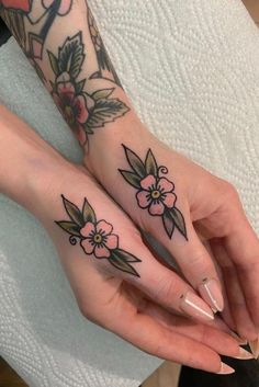 two women with matching tattoos on their hands