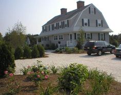 two cars parked in front of a large house