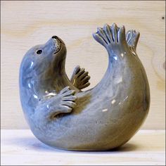 a ceramic seal sitting on top of a wooden table