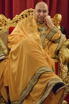 a man sitting on top of a golden chair