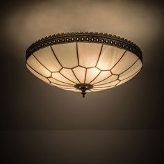 a light that is hanging from the ceiling in a room with dark walls and flooring