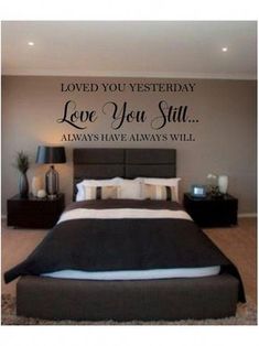 a bedroom with a large bed and wall decal that says loved you yesterday love you still