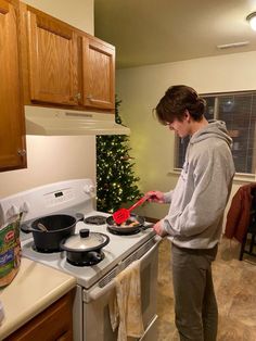 a person standing in front of a stove cooking food on top of a frying pan