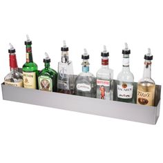 an assortment of liquor bottles are lined up in a metal holder on a white background