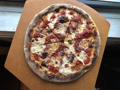 a pizza sitting on top of a wooden cutting board