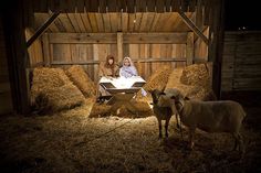 two women and a baby jesus in a mangero with hay bales on the floor