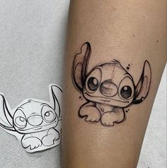 a small tattoo on the leg of a person with an image of stitch and stitch