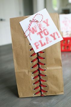 a brown paper bag with red string wrapped around it that says, way to play