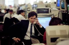 a man sitting in an office talking on the phone