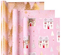 pink wrapping paper with houses and snowflakes on it, along with gold foil