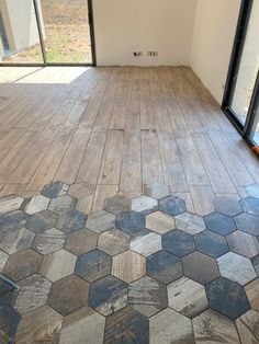 an empty room with wooden floors and glass doors