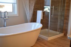 a white bath tub sitting next to a walk in shower