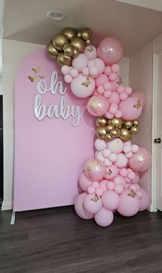 a pink and gold balloon arch for a baby shower