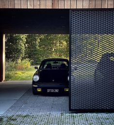 a black car is parked in front of a building with a perfored door