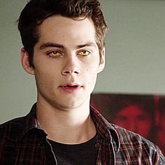 a young man with yellow eyes looking at the camera