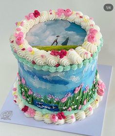 there is a cake decorated with flowers and a painting on the top of it that looks like a golf course