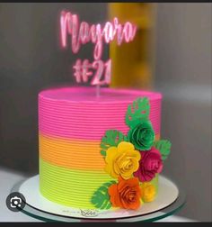 a multicolored birthday cake with flowers on top