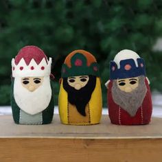 three little gnomes sitting on top of a wooden table