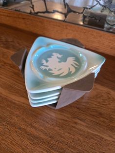 a stack of blue and white plates sitting on top of a wooden table