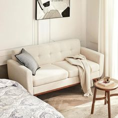 a white couch sitting next to a bed in a bedroom