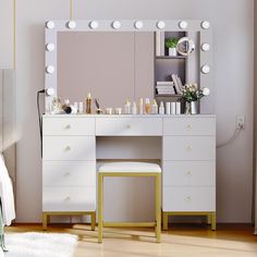 a white vanity with lights on it and a stool in front of the mirror that is open