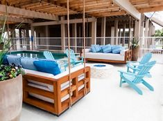 an outdoor living area with chairs, couches and a pool