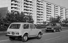 an old photo of cars driving down the road