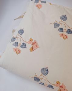 a white pillow with blue and pink flowers on it