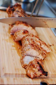 the meat is being sliced on the cutting board