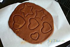 a chocolate cookie with hearts and stars on it sitting on a piece of parchment paper