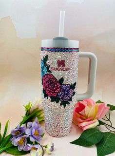 there is a coffee cup with flowers on it and the words merry written in sequins