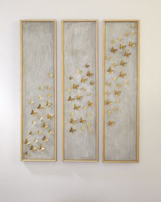 three paintings with gold butterflies on the wall