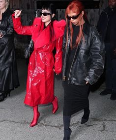 two women in black and red are walking together